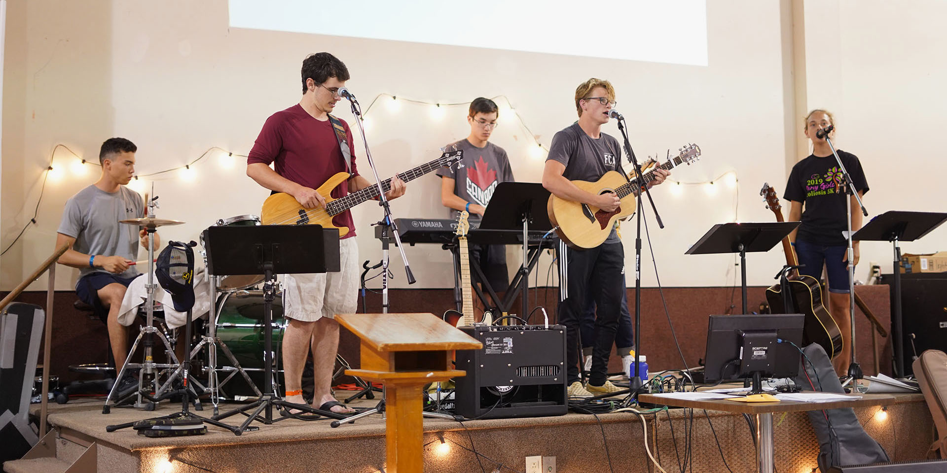 The camp worship band performs on stage.
